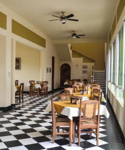 a restaurant with tables and chairs on a checkered floor at Pizzeria Colisseo B & B in Jinotepe