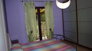 1 dormitorio con 1 cama y una ventana con cortinas en Cara Pace en Rímini