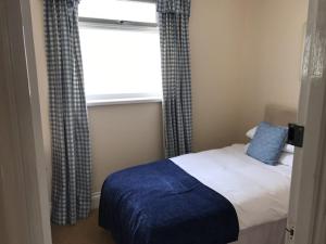 a small bedroom with a bed and a window at The Beaufort, Raglan in Raglan