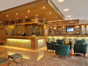 a lobby with a bar with chairs and a tv at TURIM Lisboa Hotel in Lisbon