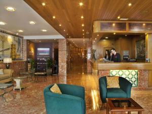 a lobby of a hotel with two people standing at a bar at TURIM Lisboa Hotel in Lisbon