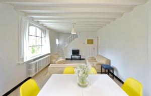 - un salon avec une table et des chaises jaunes dans l'établissement Vakantiehuis Strandpieper, à Oostduinkerke
