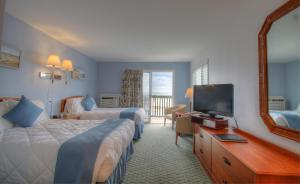 a hotel room with two beds and a mirror at Terrace By The Sea in Ogunquit