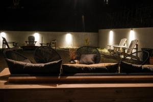 un grupo de sillas y mesas en un patio por la noche en B&B Maison Honorine en Durbuy