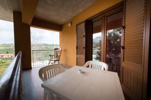 a porch with a white table and chairs on a balcony at Valle Himara in Piana degli Albanesi