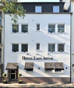 Ein weißes Gebäude mit einem Hotel-Agenten-Schild darauf. in der Unterkunft Hotel Sir & Lady Astor in Düsseldorf