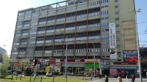 un grand bâtiment avec des personnes qui marchent devant lui dans l'établissement Apartament Centrum Arma Plac Rodła, à Szczecin