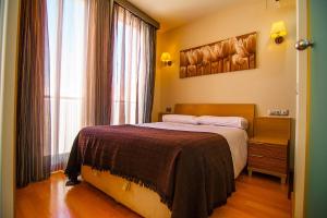 a bedroom with a bed and a large window at Dream Suites & Apartaments Almería in Almería