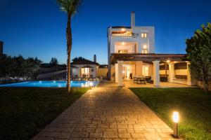 a villa with a swimming pool at night at Gennadi Beach Villas - Waterfront Luxury Retreat with Private Beach in Gennadi