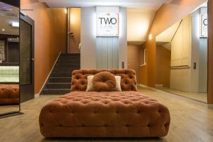 a brown couch in the middle of a lobby at TWO Hotel Berlin by Axel - Adults Only in Berlin