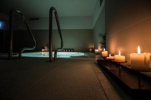 a bathroom with a swimming pool with candles and candles at TWO Hotel Berlin by Axel - Adults Only in Berlin
