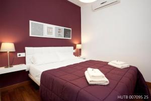 a bedroom with a large bed with two towels on it at Alcam Enamorats in Barcelona