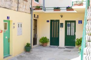 a building with green doors and potted plants at Dalmatia Sun in Split