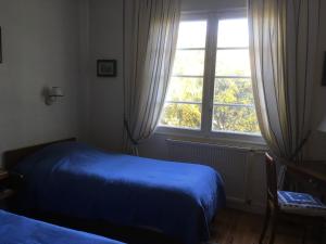 アンデルノ・レ・バンにあるVilla Pagnolのベッドルーム(青いベッド1台、窓付)