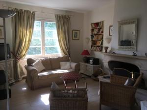ein Wohnzimmer mit Sofa und Kamin in der Unterkunft Villa Pagnol in Andernos-les-Bains