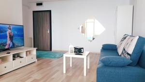 a living room with a blue couch and a tv at Summerland Sea View in Mamaia