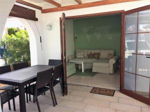 d'une terrasse avec une table, des chaises et un canapé. dans l'établissement Bungalow La Esquinita, à Maspalomas