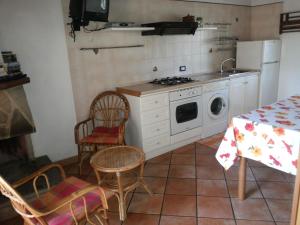 eine Küche mit einem Herd, einem Tisch und Stühlen in der Unterkunft Villino Iolanda in Marina di Camerota