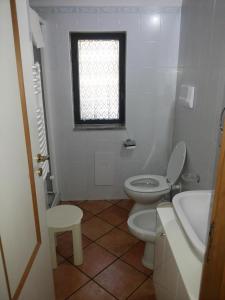 bagno con servizi igienici, lavandino e finestra di Villino Iolanda a Marina di Camerota
