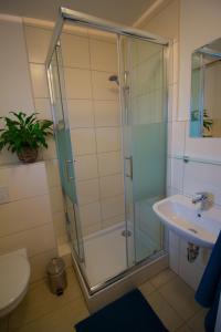 a bathroom with a glass shower and a sink at Pension König in Kassel