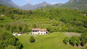 an aerial view of a house on a hill with mountains at Agriturismo Casa del Castagneto in Gargnano