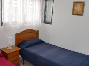 a bedroom with a bed and a dresser and a window at Kennedy 2 - Fincas Arena in Benidorm