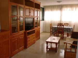 a living room with a tv and a dining room at Kennedy 2 - Fincas Arena in Benidorm