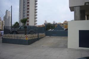 un parcheggio con recinzione e un edificio di Kennedy 2 - Fincas Arena a Benidorm