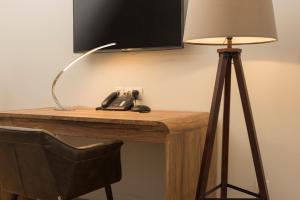 a desk with a lamp and a telephone on it at Wyndham Stuttgart Airport Messe in Stuttgart
