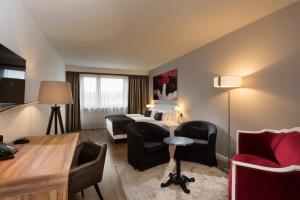 a hotel room with a bed and a table and chairs at Wyndham Stuttgart Airport Messe in Stuttgart
