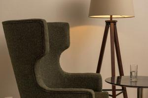 a green chair sitting next to a table with a lamp at Wyndham Stuttgart Airport Messe in Stuttgart