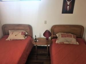 Habitación con 2 camas y mesa con lámpara. en Habitacion Santo Domingo, Heredia, en Santo Domingo