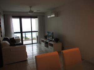sala de estar con TV, mesa y sillas en Magnífica vista para o mar, en Río de Janeiro