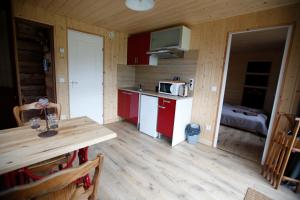 a kitchen with red cabinets and a wooden floor at Gîte Le Cerf de Belledonne in Sainte-Agnès +33 photos