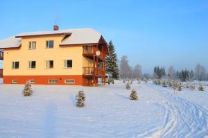 a large building in the snow with christmas trees at Karumetsa Apartment in Otepää