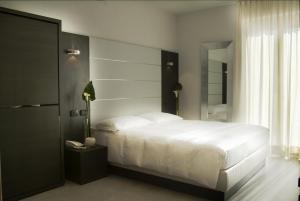 a bedroom with a large white bed and a phone at Hotel San Lorenzo Chiavenna in Chiavenna