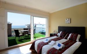 a bedroom with a bed and a balcony with a view at Hotel Beach Playa in Castelldefels