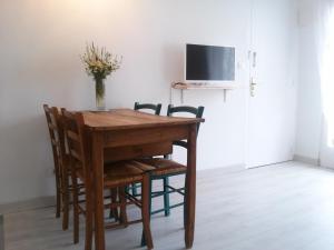 a dining room table with chairs and a vase of flowers at Acogedor apartamento en el centro de Llançà in Llança