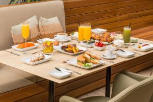 a table with breakfast foods and drinks on it at Emiliano Rio in Rio de Janeiro