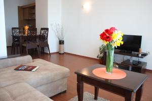 a living room with a vase of flowers on a table at White Coast Beach Apartments in Kavarna
