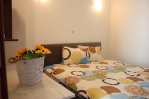 a bedroom with a bed with a vase of flowers on it at White Coast Beach Apartments in Kavarna +29 photos