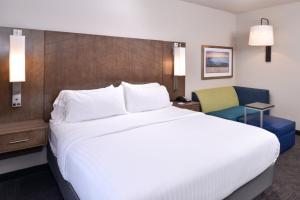 a hotel room with a large bed and a chair at Holiday Inn Express and Suites Bryant - Benton Area, an IHG Hotel in Bryant