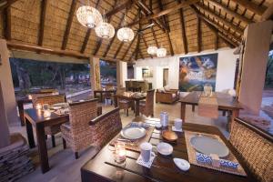 a dining room with tables and chairs and chandeliers at Bushbaby River Lodge in Hoedspruit