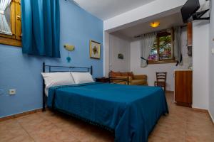 a bedroom with blue walls and a bed with blue sheets at Niriides in Ammouliani