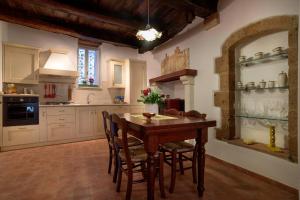 eine Küche mit einem Holztisch und Stühlen in der Unterkunft Casetta Nella Fratta in Pitigliano
