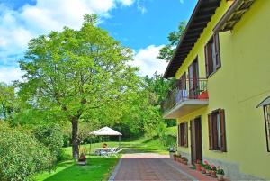 a building with a tree next to a brick walkway at B&B Marienn in Gavardo