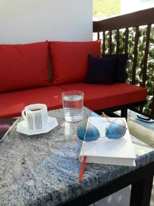 una mesa con gafas de sol y un sofá rojo en Apartment Maja en Budva