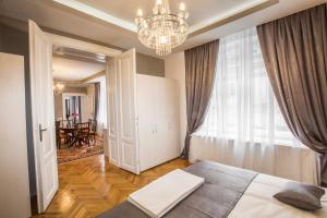 um quarto com uma cama e um lustre em Weidner Apartments em Sibiu