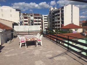 a patio with a table and chairs on a roof at Crveno Zlato in Biograd na Moru