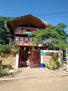 Cette petite maison est dotée d'un toit de chaume. dans l'établissement Wiracocha Hostal Máncora - Surf Camp, à Máncora
